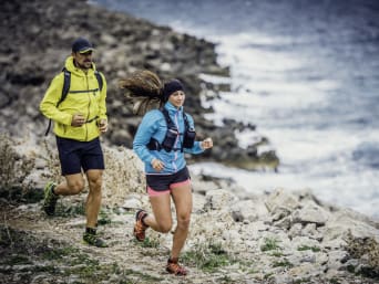 Trail running essentials: two runners wearing running clothes and carrying water bottles. Trail running essentials: two runners wearing running clothes and carrying water bottles.