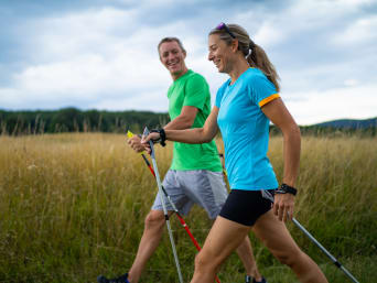 Nordic walking for beginners: a woman learning the Nordic walking technique from an instructor. Nordic walking for beginners: a woman learning the Nordic walking technique from an instructor.