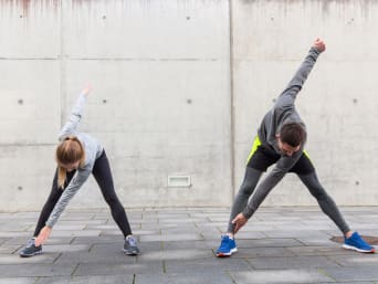Warming up before going for a run: running partners doing warm-up exercises together. Warming up before going for a run: running partners doing warm-up exercises together.