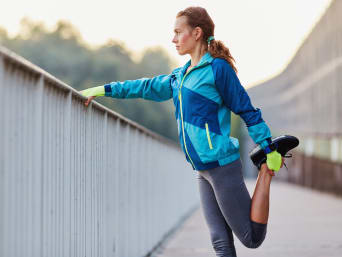 Stretching after running: a woman doing cool-down exercises after going on a run. Stretching after running: a woman doing cool-down exercises after going on a run.