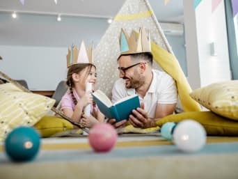 Voorlezen aan kinderen:  Een vader leest zijn dochter een sprookje voor.  Voorlezen aan kinderen:  Een vader leest zijn dochter een sprookje voor.