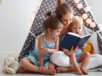 Leesbevordering op jonge leeftijd: Moeder leest met haar kinderen een boek. Leesbevordering op jonge leeftijd: Moeder leest met haar kinderen een boek.