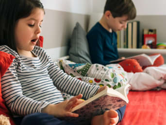 Lesemotivation fördern: Bruder und Schwester verbringen gemeinsame Lesezeit miteinander. Lesemotivation fördern: Bruder und Schwester verbringen gemeinsame Lesezeit miteinander.