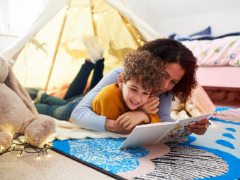 Kinder zum Lesen motivieren: Mutter und Sohn lesen gemeinsam im gemütlichen Kinderzimmer. Kinder zum Lesen motivieren: Mutter und Sohn lesen gemeinsam im gemütlichen Kinderzimmer.
