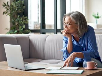 Sicheres Passwort – ältere Dame denkt sich ein Passwort am Laptop aus. Sicheres Passwort – ältere Dame denkt sich ein Passwort am Laptop aus.