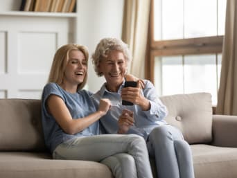 Handy Hilfe für Senioren: Frau hilft ihrer Mutter beim Einrichten des Smartphones. Handy Hilfe für Senioren: Frau hilft ihrer Mutter beim Einrichten des Smartphones.