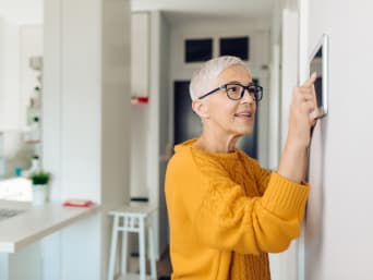 Smart Home – Frau öffnet das Türschloss über das Smart-Home-System. Smart Home – Frau öffnet das Türschloss über das Smart-Home-System.