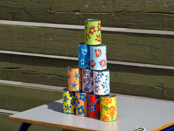 Stitch party supplies: cans with bright flowers for playing a ball and can game. Stitch party supplies: cans with bright flowers for playing a ball and can game.