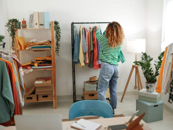Minimalist lifestyle: a woman sorting through her clothes in her minimalist style flat.  Minimalist lifestyle: a woman sorting through her clothes in her minimalist style flat.