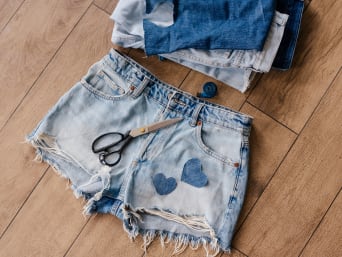 Upcycling clothes: a pair of denim shorts with heart patches. Upcycling clothes: a pair of denim shorts with heart patches.