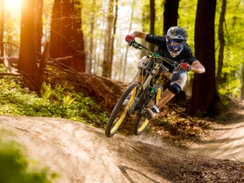 Downhill: Ein Mountainbiker fährt mit seinem Bike einen eine Downhillstrecke hinab. Downhill: Ein Mountainbiker fährt mit seinem Bike einen eine Downhillstrecke hinab.