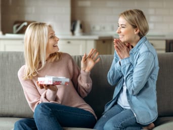Adult daughter gives her mother a Mother's Day gift. Adult daughter gives her mother a Mother's Day gift.