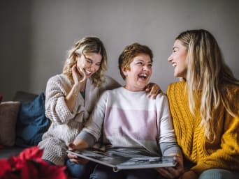 Mother's Day gift idea: Mother receives a photo album as a gift from her daughters. Mother's Day gift idea: Mother receives a photo album as a gift from her daughters.
