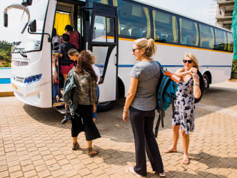 Eco-friendly travel: holidaymakers getting on a coach. Eco-friendly travel: holidaymakers getting on a coach.