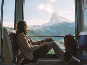 A woman travelling on a train to Switzerland. A woman travelling on a train to Switzerland.
