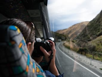 Eco-travel: a woman travelling by coach taking pictures of the passing scenery. Eco-travel: a woman travelling by coach taking pictures of the passing scenery.