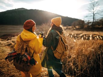 Minimalist travel tips: two holidaymakers carrying a rucksack and eco-friendly water bottles. Minimalist travel tips: two holidaymakers carrying a rucksack and eco-friendly water bottles.