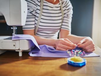 Repairing clothes: a woman is using old clothes to sew something new.  Repairing clothes: a woman is using old clothes to sew something new.