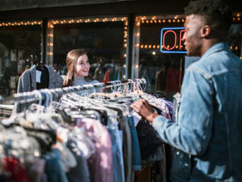 Tips on buying second-hand clothes: two friends looking at vintage clothes in a second-hand shop.  Tips on buying second-hand clothes: two friends looking at vintage clothes in a second-hand shop.
