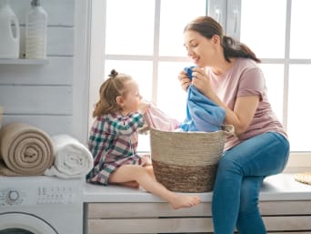 Milieuvriendelijk wassen: moeder en kind ruiken aan de frisse was. Milieuvriendelijk wassen: moeder en kind ruiken aan de frisse was.