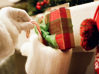Kleine Nikolaus-Geschenke: Nikolaus befüllt eine Nikolaussocke mit Geschenken. Kleine Nikolaus-Geschenke: Nikolaus befüllt eine Nikolaussocke mit Geschenken.
