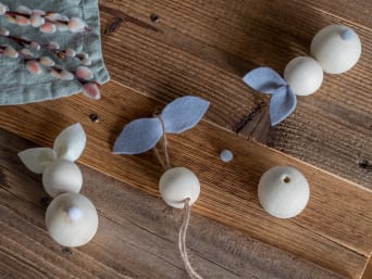 Tischdeko Ostern basteln: die Holzhasen kannst du zusammen mit deinen Kindern basteln.