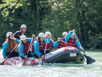 Unterengadin Rafting: Eine Gruppe rudert mit ihrem Floss auf einem Fluss.