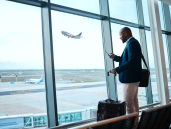 Plan a business trip: a man waiting at an airport for his flight.   Plan a business trip: a man waiting at an airport for his flight.