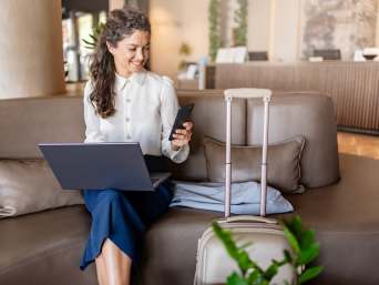 Plan a business trip: a woman working in a hotel lobby.  Plan a business trip: a woman working in a hotel lobby.