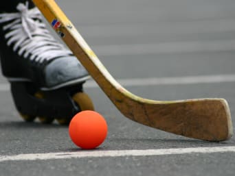 Inline-Skaterhockey – Nahaufnahme von Ball und Schläger. Inline-Skaterhockey – Nahaufnahme von Ball und Schläger.