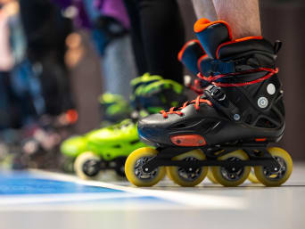 Speed Skating: Athleten stehen an der Startlinie einer Hallenbahn.