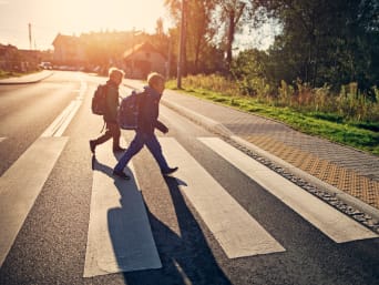 Kinder im Straßenverkehr: Zwei Kinder überqueren einen Fußgängerüberweg. Kinder im Straßenverkehr: Zwei Kinder überqueren einen Fußgängerüberweg.