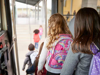 Schulweg mit dem Bus – Schulkinder steigen nacheinander aus dem Bus aus. Schulweg mit dem Bus – Schulkinder steigen nacheinander aus dem Bus aus.