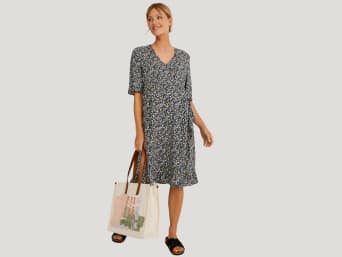 Stylish pregnancy fashion: a woman wearing a printed wrap dress to hide her pregnancy bump. Stylish pregnancy fashion: a woman wearing a printed wrap dress to hide her pregnancy bump.