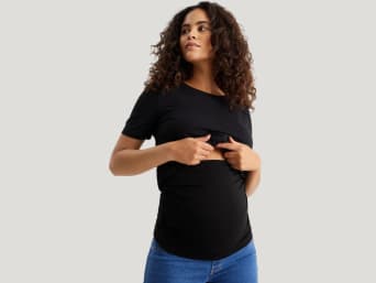 Modern maternity fashion: a pregnant woman wearing a belly band under her T-shirt. Modern maternity fashion: a pregnant woman wearing a belly band under her T-shirt.