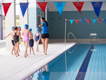 Schwimmabzeichen: Kinder mit ihrer Trainerin beim Schwimmkurs im Hallenbad. Schwimmabzeichen: Kinder mit ihrer Trainerin beim Schwimmkurs im Hallenbad.