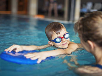 Schwimmen lernen: Kleiner Junge übt das Schwimmen im Hallenbad. Schwimmen lernen: Kleiner Junge übt das Schwimmen im Hallenbad.