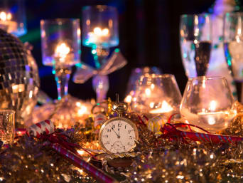 Glinsterende gouden nieuwjaar versiering met champagneglazen op een tafel. Glinsterende gouden nieuwjaar versiering met champagneglazen op een tafel.
