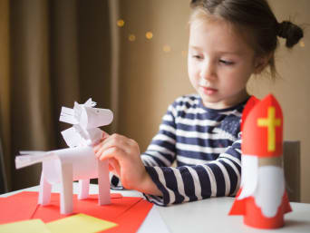 Kind maakt een Sinterklaas knutsel van gekleurd papier. Kind maakt een Sinterklaas knutsel van gekleurd papier.