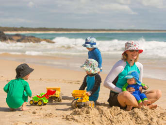 Sonnenschutz Baby: Kleinkinder in UV-Schutzkleidung am Strand. Sonnenschutz Baby: Kleinkinder in UV-Schutzkleidung am Strand.
