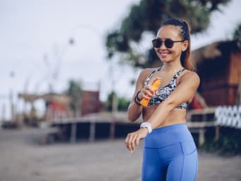 Sonnenschutz beim Sport: Joggerin cremt sich mit geeigneter Sport-Sonnencreme ein. Sonnenschutz beim Sport: Joggerin cremt sich mit geeigneter Sport-Sonnencreme ein.