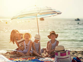 Sonnenschutzmittel im Vergleich: Sonnencreme und -schirm bieten doppelten Sonnenschutz am Strand. Sonnenschutzmittel im Vergleich: Sonnencreme und -schirm bieten doppelten Sonnenschutz am Strand.