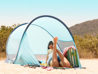 Eine Strandmuschel mit Seitenwänden bietet Wind- und Sonnenschutz am Strand. Eine Strandmuschel mit Seitenwänden bietet Wind- und Sonnenschutz am Strand.