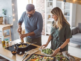 Duurzaamheid in het dagelijks leven - echtpaar kookt een vegetarisch gerecht met seizoensgroenten. Duurzaamheid in het dagelijks leven - echtpaar kookt een vegetarisch gerecht met seizoensgroenten.
