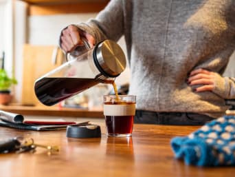 Ecologisch leven - Vrouw schenkt koffie in haar herbruikbare mok. Ecologisch leven - Vrouw schenkt koffie in haar herbruikbare mok.