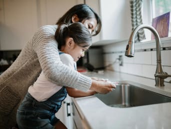 Water besparen - moeder en dochter wassen hun handen. Water besparen - moeder en dochter wassen hun handen.
