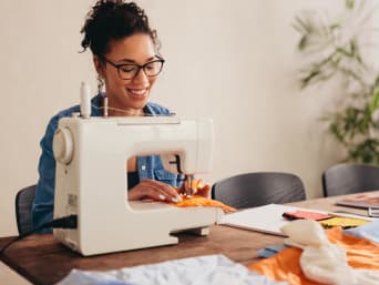 Tips om geld te besparen - studente repareert haar kleding.