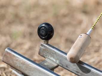 Hornussen: Nahaufnahme eines Steckens, der sich dem Hornuss auf dem Bock nähert. Hornussen: Nahaufnahme eines Steckens, der sich dem Hornuss auf dem Bock nähert.