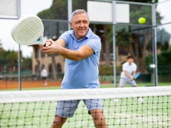 Padel-Tennis Ausrüstung: Ein älterer Mann in Sportkleidung spielt ein Padel-Match. Padel-Tennis Ausrüstung: Ein älterer Mann in Sportkleidung spielt ein Padel-Match.
