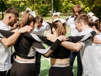 Cheerleading-Ausrüstung: Ein Cheerleading-Team steht in einem Kreis und bespricht sich. Cheerleading-Ausrüstung: Ein Cheerleading-Team steht in einem Kreis und bespricht sich.